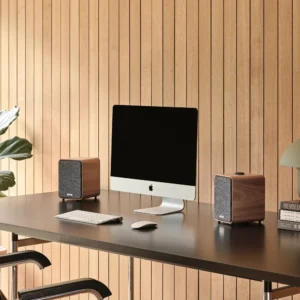 Ruark MR1 MK3 Desktop-Lautsprecher Walnuss beispielhaft abgebildet neben Mac auf Schreibtisch