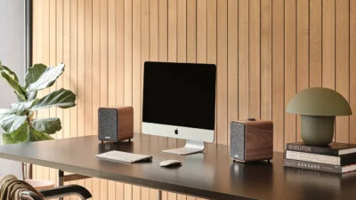 Ruark MR1 MK3 Desktop-Lautsprecher Walnuss beispielhaft abgebildet neben Mac auf Schreibtisch