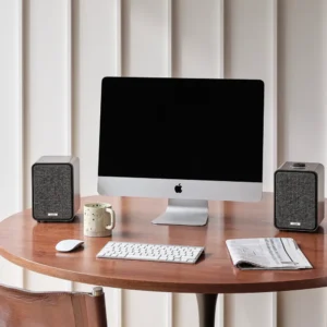 Ruark MR1 MK3 Desktop-Lautsprecher Walnuss, beispielhaft abgebildet neben Mac und Tastatur auf Schreibtisch